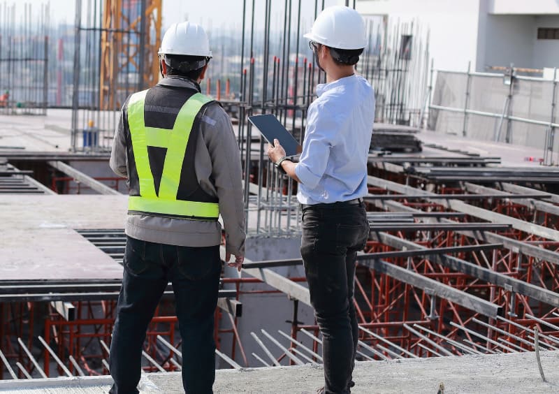 2 hommes sur chantier construction maitre d'oeuvre batiment professionnel