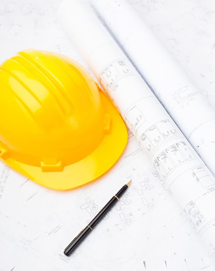 casque chantier jaune et plan de maisons avec stylo par ACADIE, constructeur drome et ardeche