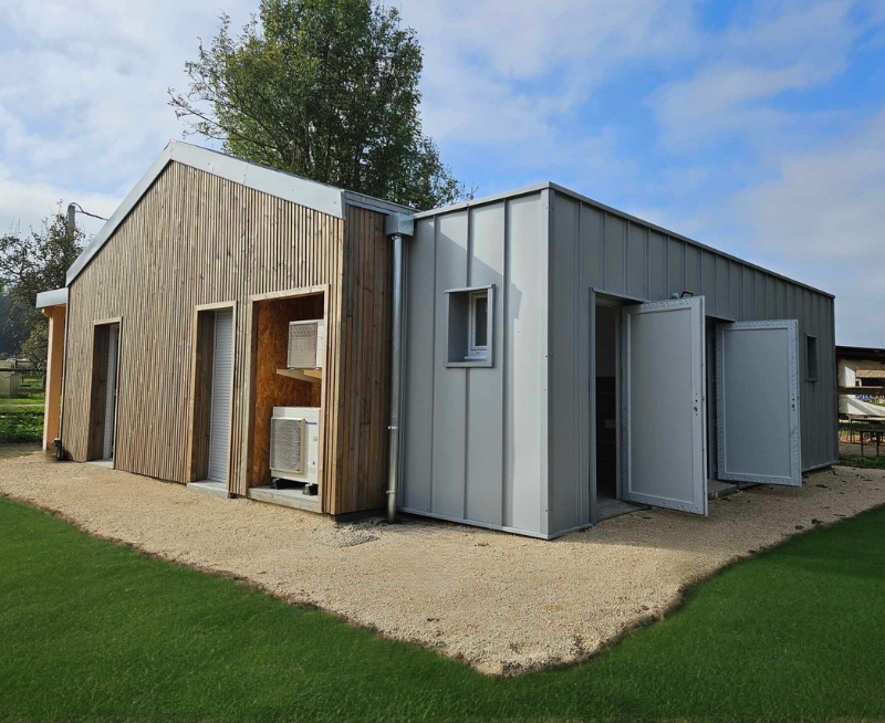 Bâtiment professionnel avec façade rouge et cour goudron par Acadie, specialiste construction batiment professionnel drome. 